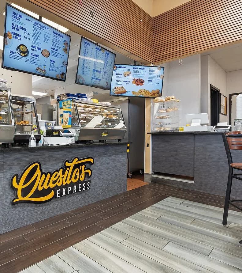 Inside a Quesito's Express location, with the lit-up logo on the front counter